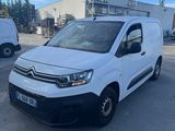 une camionnette blanche garée sur un parking à côté d'un bâtiment