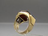 a close up of a gold ring with a garnetite and diamonds