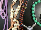 several necklaces and bracelets are displayed on a black surface