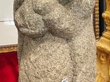 a statue of a man holding a baby on a red blanket