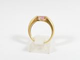 a gold ring with a pink stone in the center