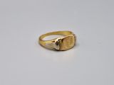 a close up of a gold signet ring on a white surface