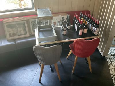 deux chaises placées à côté d'une table sur laquelle se trouvent des bouteilles de vin