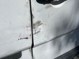 a white van with a black door handle and a sticker on it