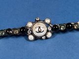 a close up of a black and white beaded bracelet with pearls