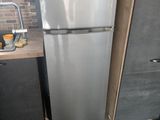 a silver refrigerator in a small kitchen with a sink
