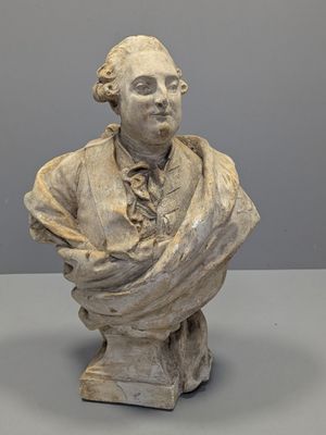 buste en marbre représentant un homme en costume-cravate, assis sur une table