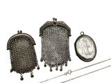 deux bourses en argent et une chaîne munie d'un cadenas sur fond blanc