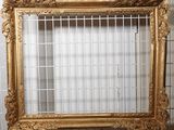 une photo représentant un cadre doré accroché au mur