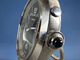 an image of a close up of a silver watch on a blue background