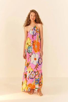 a woman in a pink floral dress standing in front of a white background