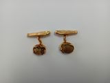 a pair of gold plated cufflinks with leaves and leaves on them