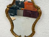 a mirror hanging on the wall with a bird on it