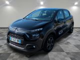 Une Citroën noire est garée dans une pièce au sol carrelé en damier.