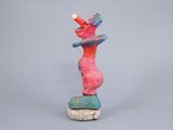 statue of a woman holding a baseball bat on top of a rock