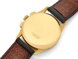 a close up of a watch on a white surface with a brown strap