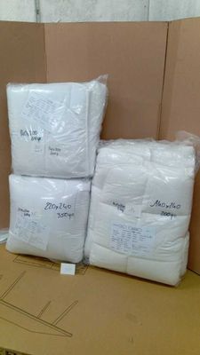 des cartons contenant des oreillers blancs empilés les uns sur les autres dans une pièce