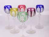 six verres à vin alignés sur une surface blanche