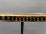 un gros plan d'une table dorée et noire percée de trous