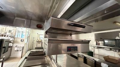 several stainless steel ovens are stacked on top of each other in a kitchen