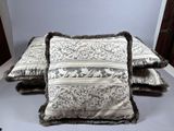three decorative pillows on a white table with a blue wall in the background
