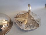 a silver plate with a silver lid and a silver plate with a silver lid