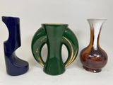 three vases sitting next to each other on a white surface