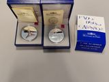 a silver coin in a blue box with a box of cards