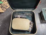 une valise posée par terre, contenant une montre