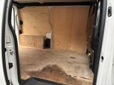 a small white van with the door open in a garage