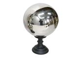 une boule argentée posée sur un socle noir, sur fond blanc