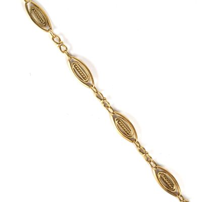 gros plan d'un bracelet en or sur fond blanc