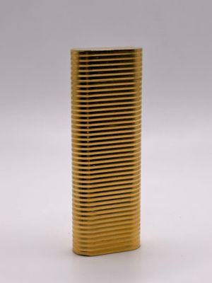une photo d'un briquet doré posé sur une table blanche