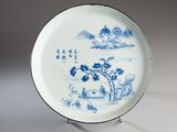a blue and white plate with a landscape on it