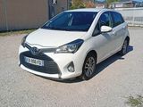 La petite voiture blanche est garée sur le parking, à côté d'un immeuble.