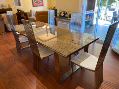 a glass table and chairs in a room with wood floors