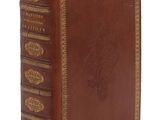 un livre en cuir marron avec des garnitures dorées sur la couverture