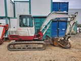 a small excavator parked in front of a building