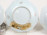 three blue and white plates with gold trims and a plate with a gold rim