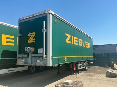 a green and yellow semi truck parked in a parking lot
