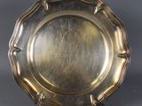 a silver plate on a stand on a grey background