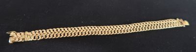 a close up of a gold bracelet on a black surface