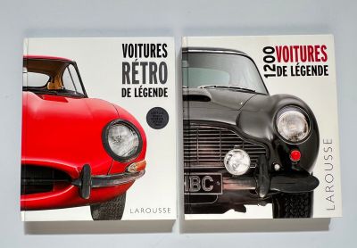 deux livres posés sur une surface blanche, avec une voiture rouge et une voiture noire