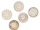 un ensemble de cinq pièces d'argent sur un fond blanc
