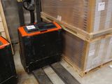 a fork lifter in a warehouse next to a stack of boxes