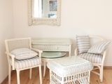 une table et des chaises dans une pièce où un miroir est accroché au mur