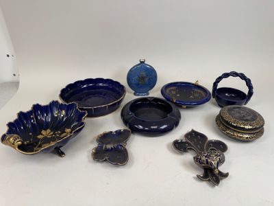 several pieces of blue and gold pottery sitting on a white surface