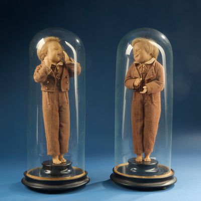 two figurines of a man and a woman under a glass dome