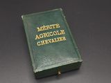 a green book with gold lettering sitting on a black surface