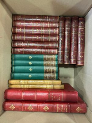 several books are stacked in a cardboard box on a table
